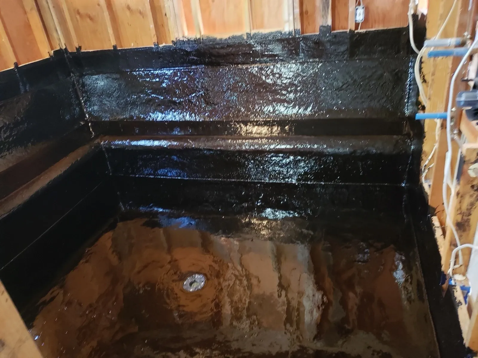 A black tub with brown water in it
