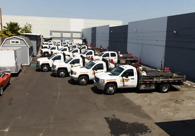 A group of white trucks parked in front of a building.